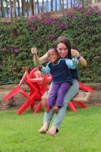 A volunteer swings with a Tanzanian orphan (photo The Small Things).
