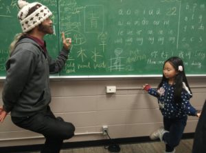 A Camosun student learns from a young guest at the Mandarin Club (photo provided).